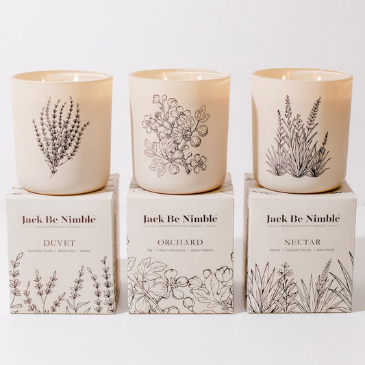 Three candles with botanical designs on boxes labeled 'Jack Be Nimble' on a white background.