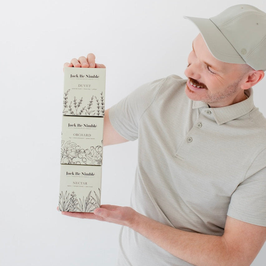Paul the founder of Jack Be Nimble holding a candle boxes with a white background